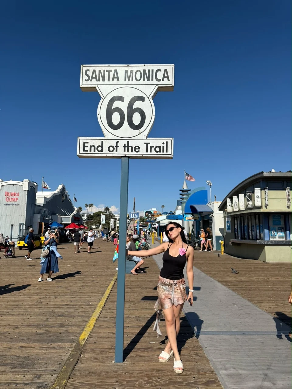 Santa Monica Route 66 тэмдгийн дэргэдэх аялагч